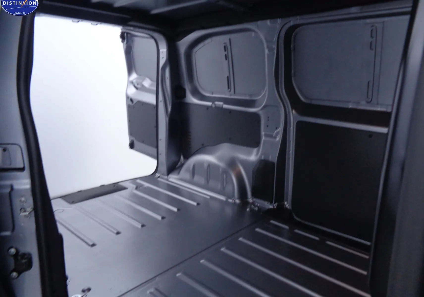 Intérieur du coffre gris métallisé du Peugeot Expert Fourgon 2022, vue depuis l'arrière avec porte latérale ouverte.