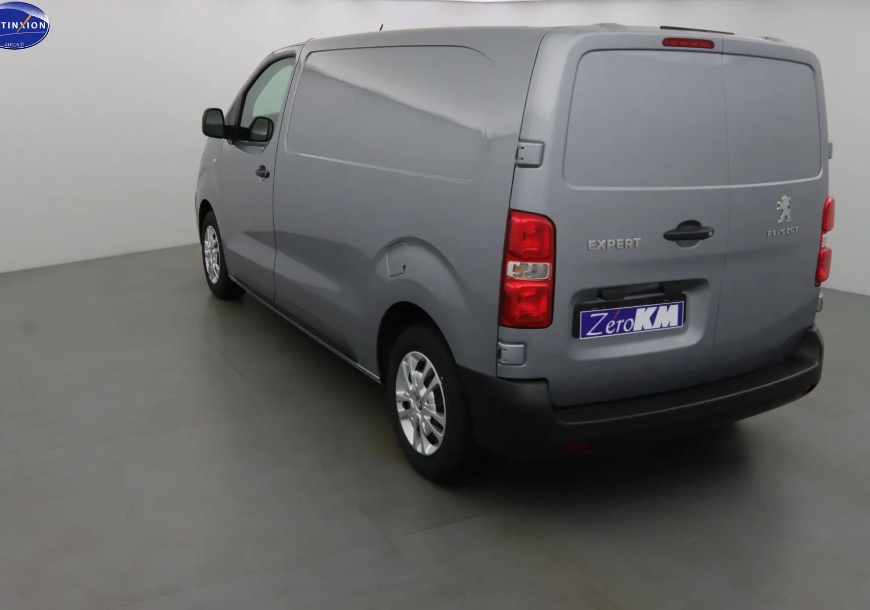Vue 3/4 arrière droit d'un Peugeot Expert Fourgon gris Artense métallisé avec portes arrière fermées dans un studio.