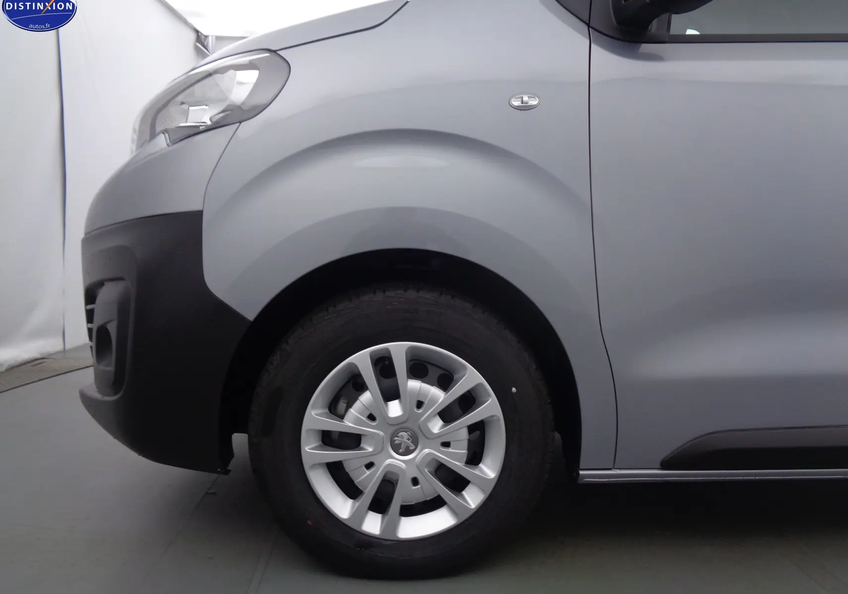 Gros plan sur la roue avant gauche et l'aile grise Artense métal du Peugeot Expert Fourgon 2022, finition Premium.