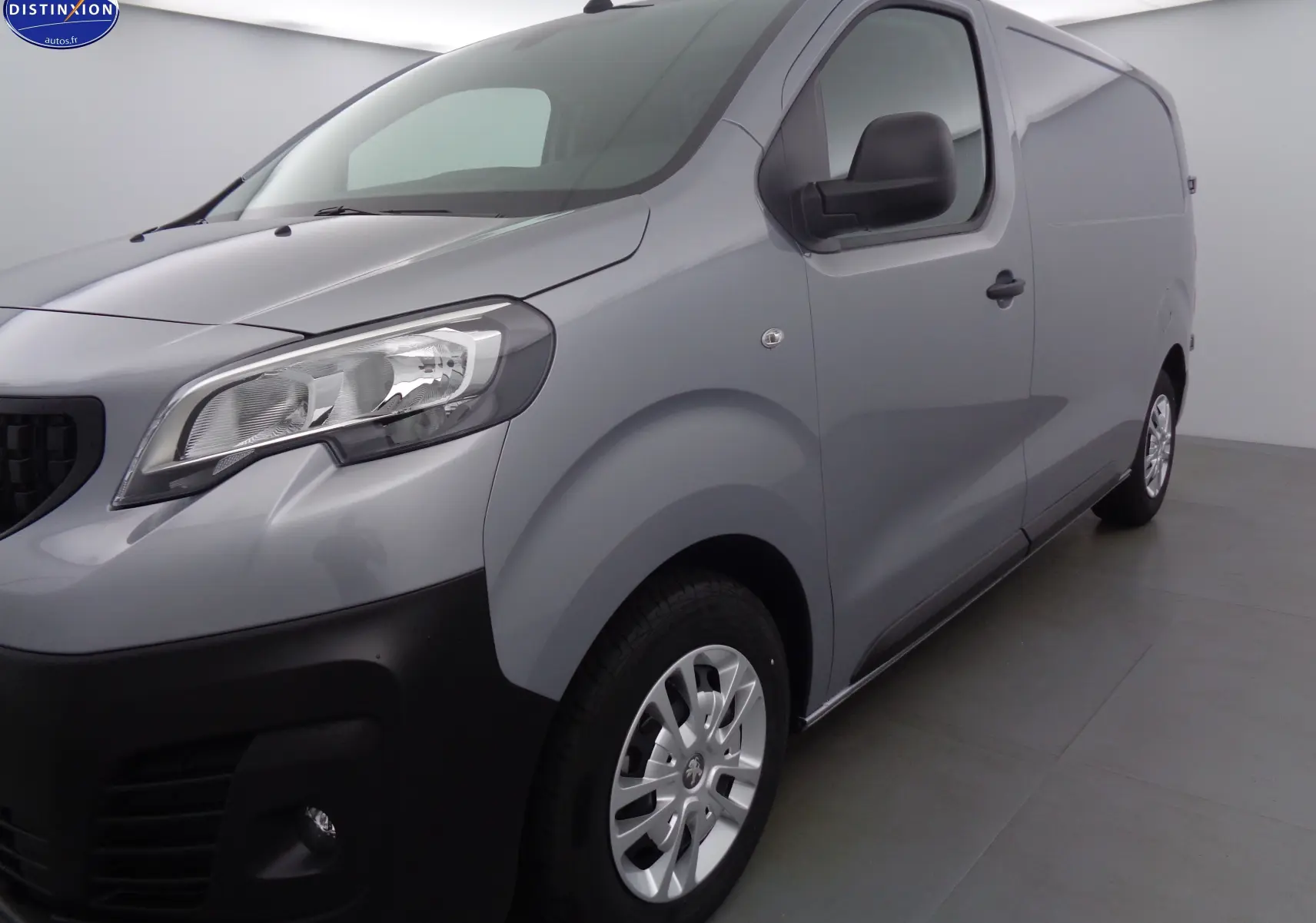 Vue 3/4 avant droit du Peugeot Expert Fourgon gris Artense métal, avec pare-chocs noir et jantes argentées.