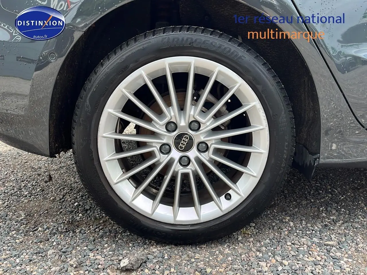 Gros plan sur la jante alu 17 pouces argentée avec logo Audi sur une Audi A3 Sportback gris Manhattan.