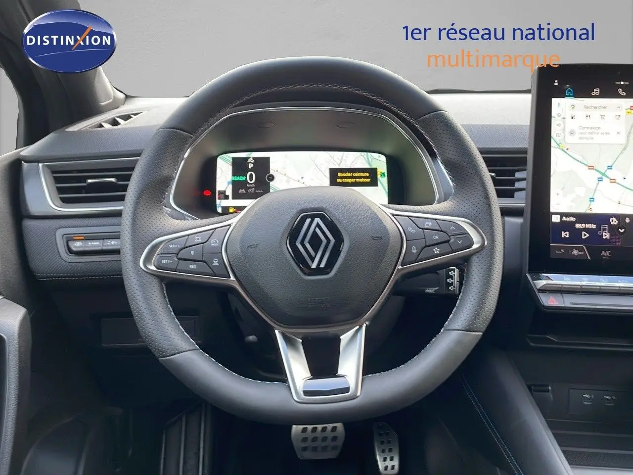 Vue frontale centrée sur le volant noir perforé du Renault Captur E-Tech avec tableau de bord numérique et écran tactile.