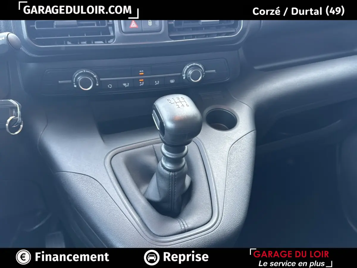 Gros plan sur le levier de vitesses manuel du Peugeot Rifter 2024, tableau de bord et commandes de climatisation visibles.
