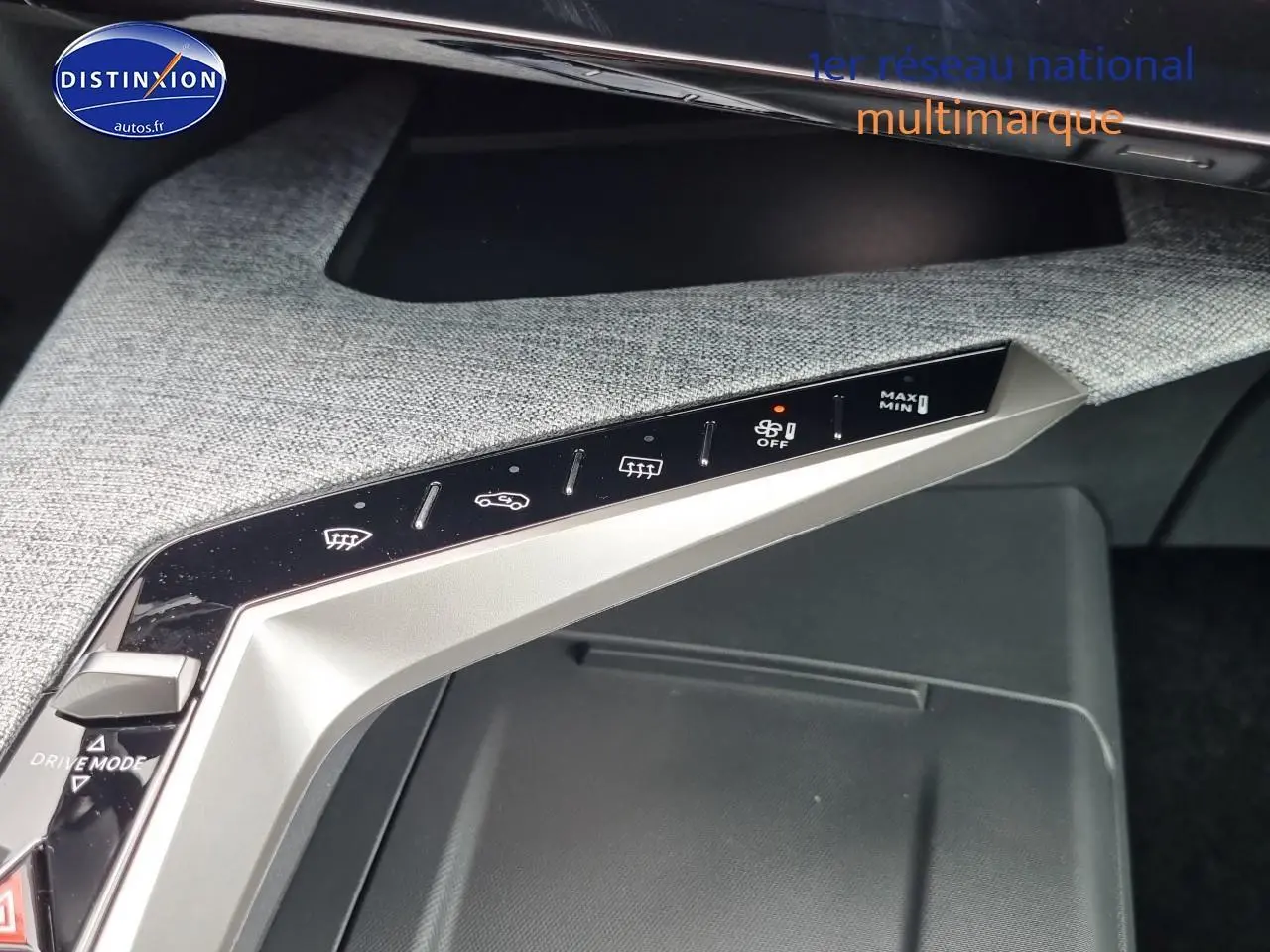 Vue rapprochée du panneau de commandes de climatisation et mode de conduite sur la console centrale grise du Peugeot 3008 blanc.