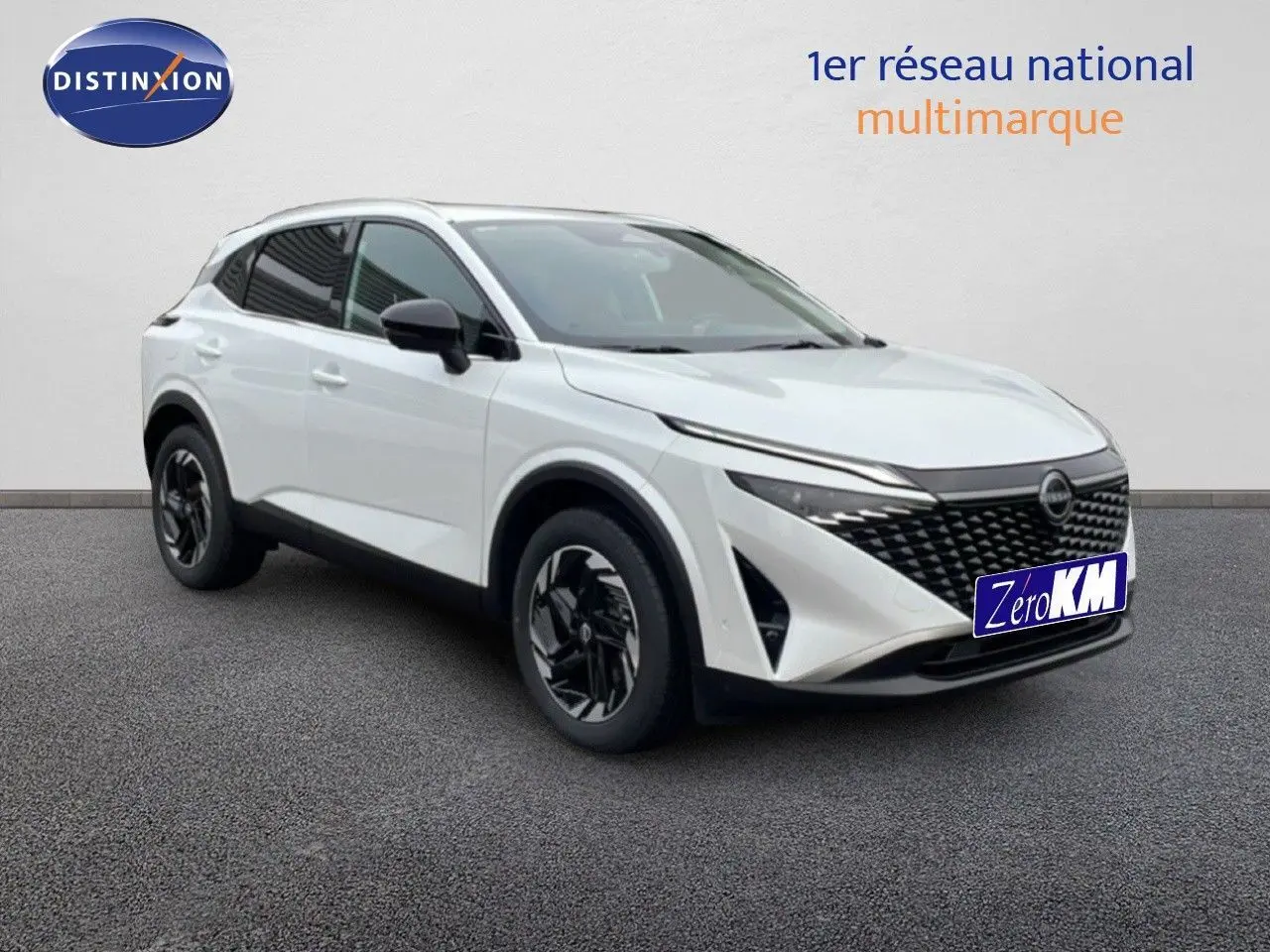 Nissan Qashqai blanc nacré métal en 3/4 avant droit, avec calandre noire et jantes bicolores.