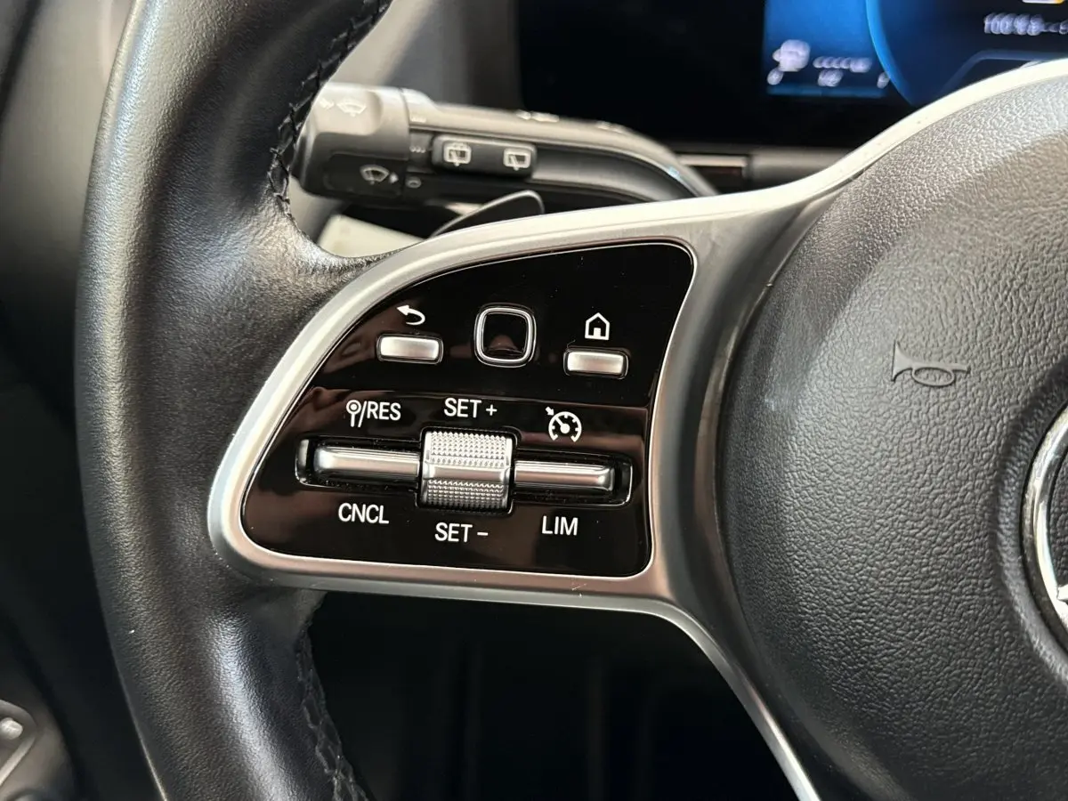 Gros plan sur les commandes du volant cuir noir d’une Mercedes GLA 250 e Business Line 2021.