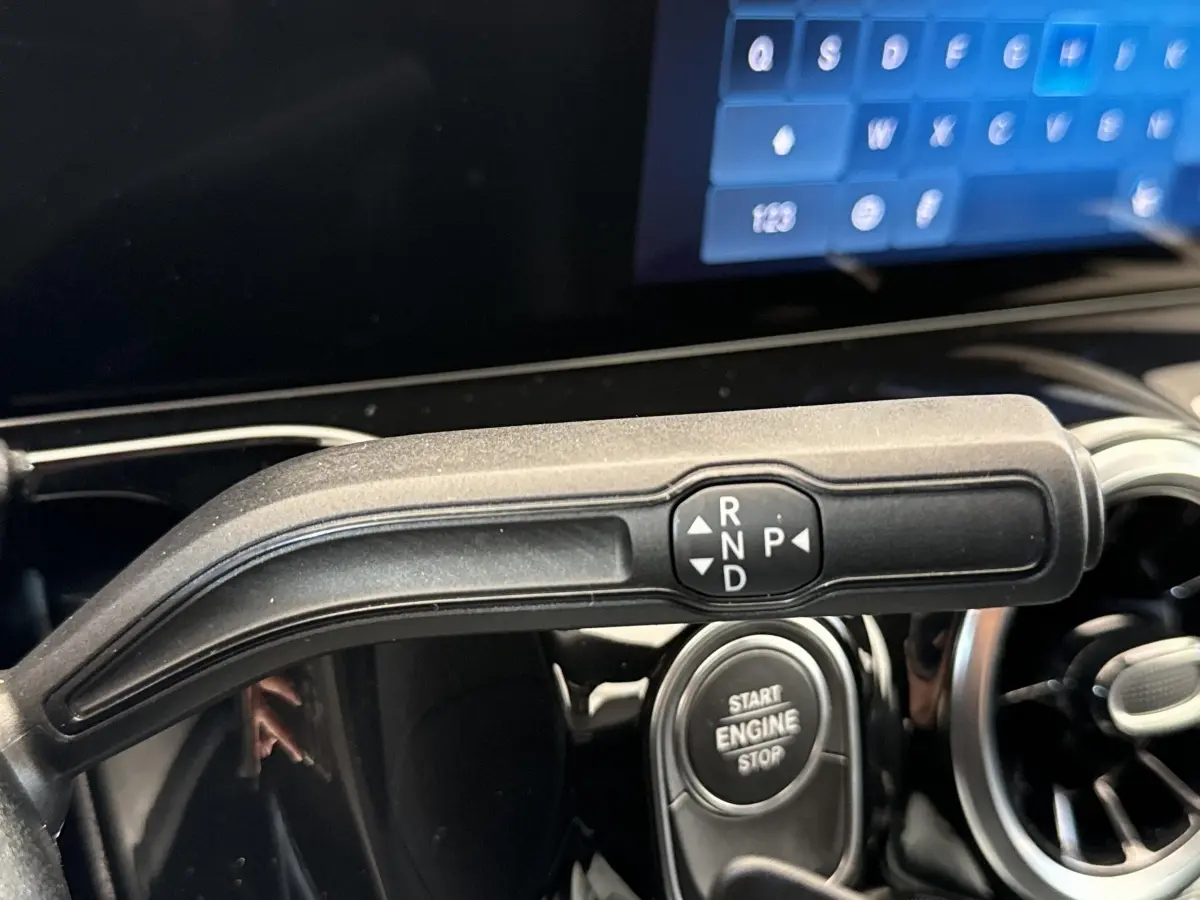 Gros plan sur la commande de boîte automatique et bouton start/stop dans l’habitacle d’un Mercedes GLA bleu.