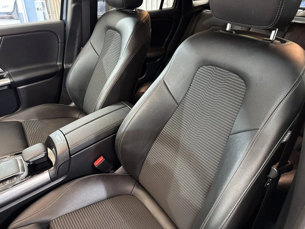 Gros plan sur les sièges avant noirs en cuir et tissu du Mercedes GLA 250 e Business Line, vue côté droit.
