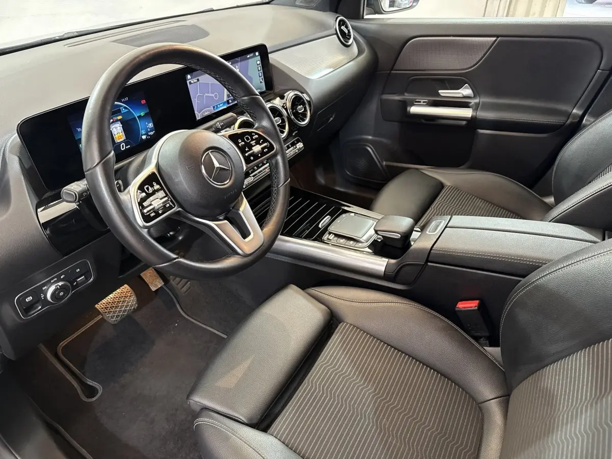 Intérieur noir de la Mercedes GLA 250 e 2021, vue côté conducteur avec tableau de bord digital et console centrale moderne.