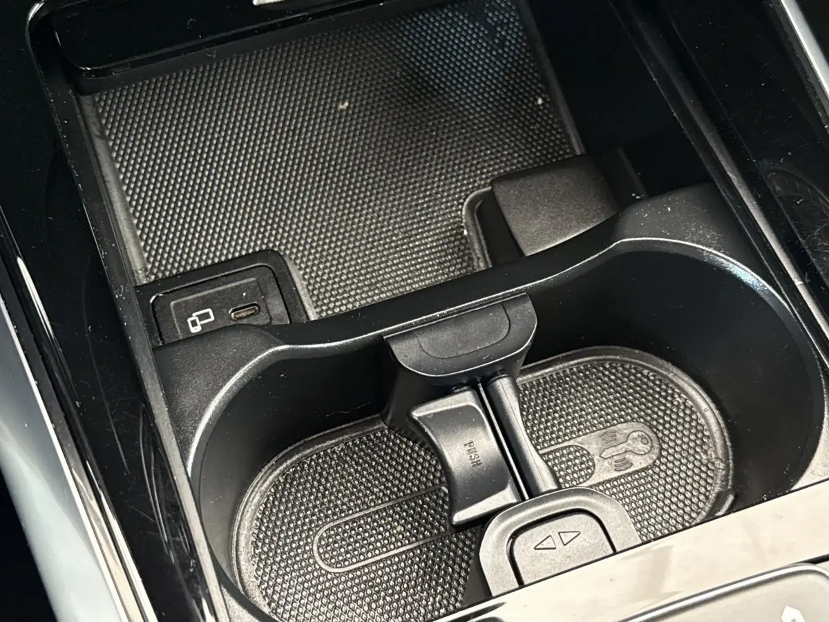 Gros plan sur le porte-gobelets noir et la console centrale du Mercedes GLA 250 e bleu, intérieur moderne et épuré.