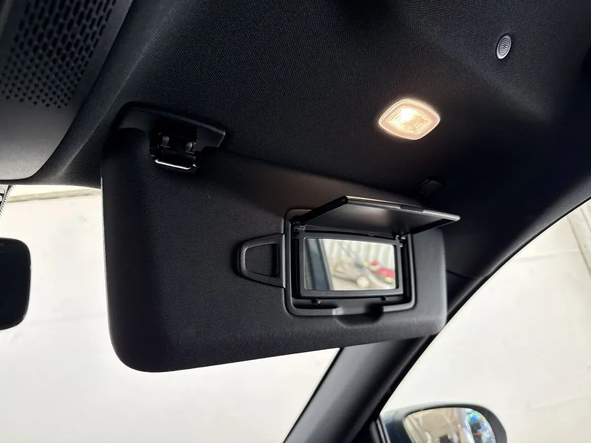Miroir de courtoisie ouvert sur pare-soleil côté conducteur dans l'habitacle d'un Mercedes GLA bleu 2021.