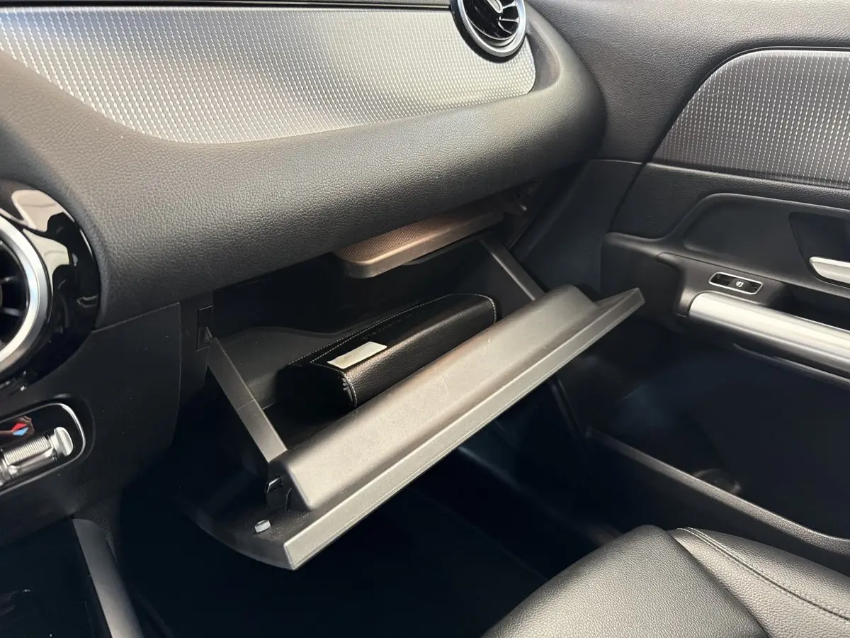 Intérieur du Mercedes GLA 250 e 2021, vue côté passager sur la boîte à gants ouverte avec un étui noir.