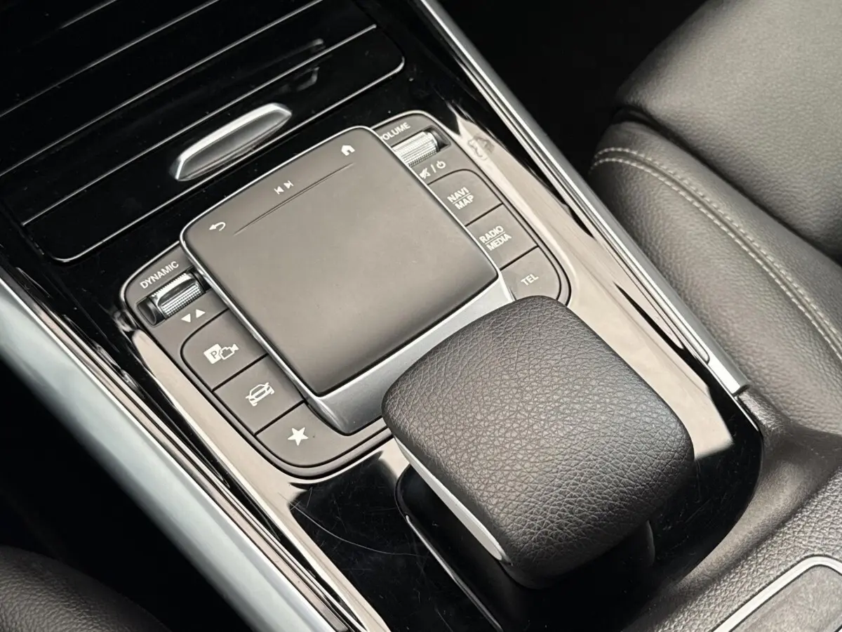 Gros plan sur la console centrale noire avec touchpad et commandes du Mercedes GLA 250 e Business Line 2021.