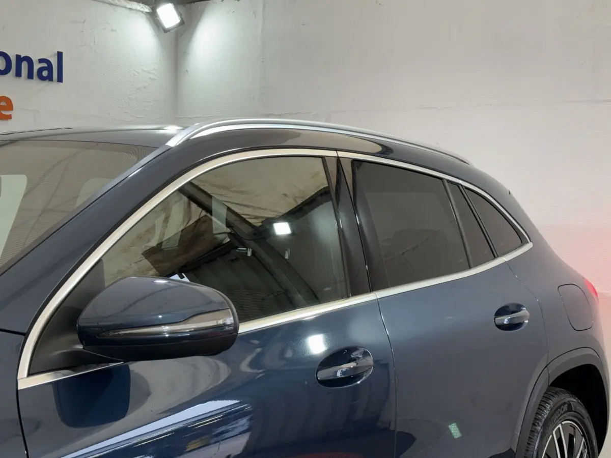 Vue latérale gauche d’un Mercedes GLA 250 e Business Line bleu avec vitres teintées et rétroviseurs chromés.