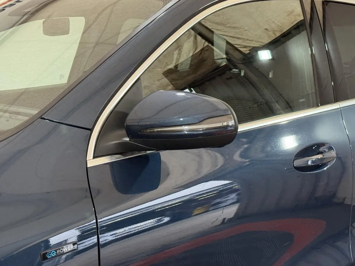 Gros plan sur le rétroviseur et la portière côté gauche d'une Mercedes GLA 250 e Business Line bleu métallisé.