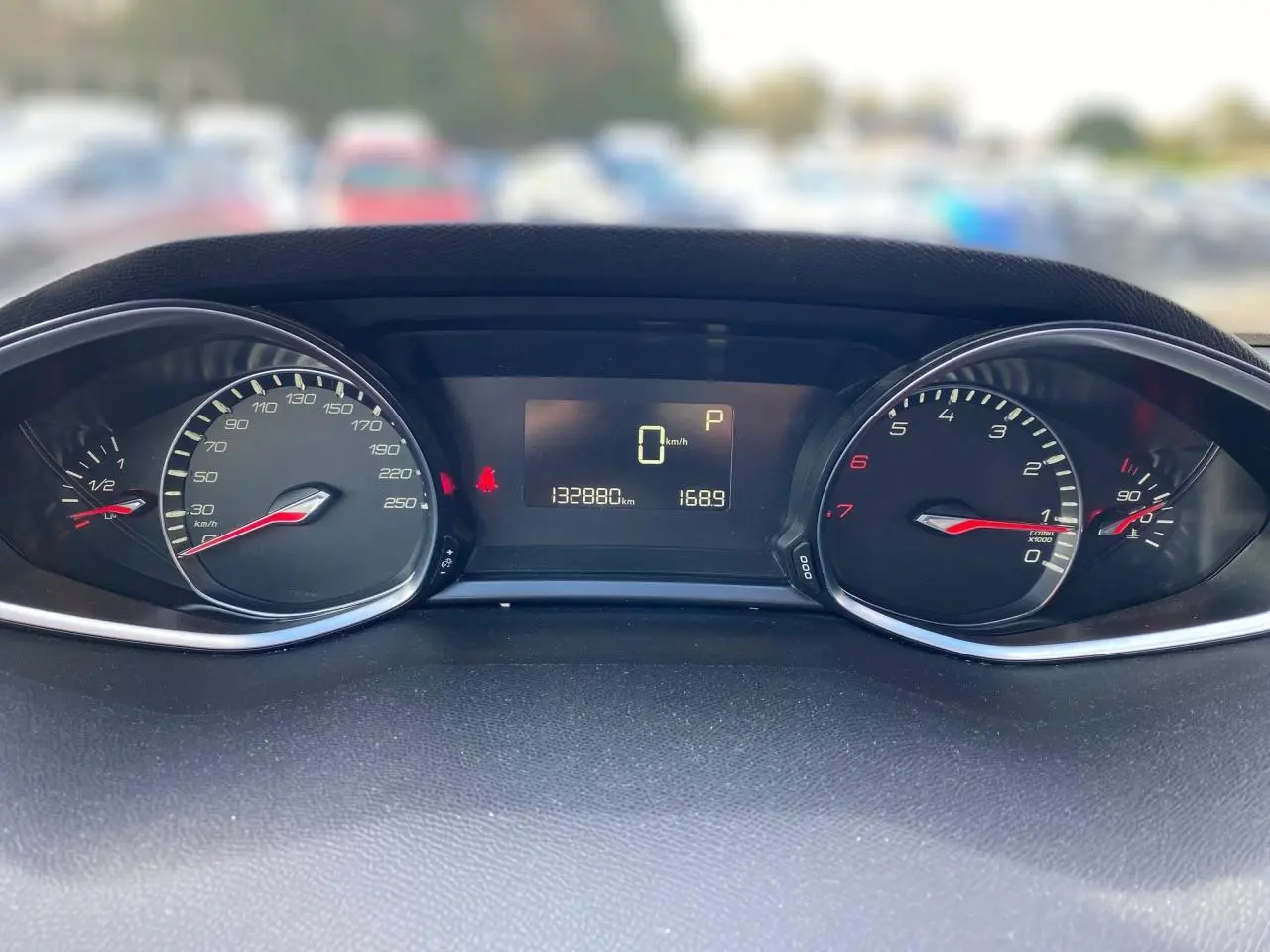 Tableau de bord de Peugeot 308 gris aluminium, affichant compteur et compte-tours avec écran central numérique.