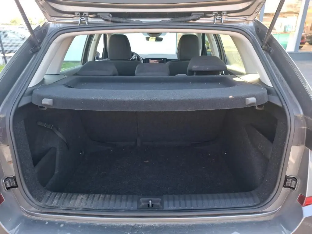 Coffre ouvert vu de l'arrière d'un Skoda Kamiq gris foncé 2023, montrant l'espace de chargement et l'intérieur noir.