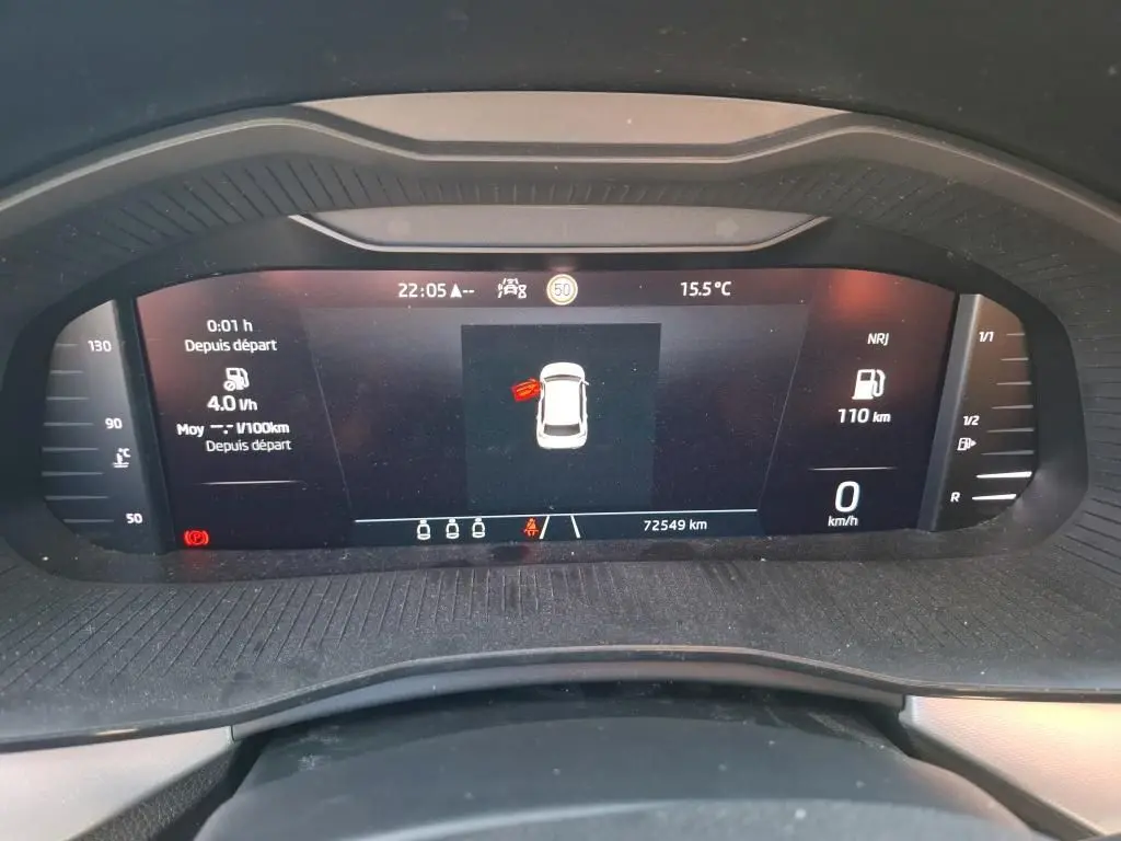 Vue rapprochée du tableau de bord numérique du Skoda Kamiq gris foncé, affichant la vitesse à 0 km/h et une porte ouverte.