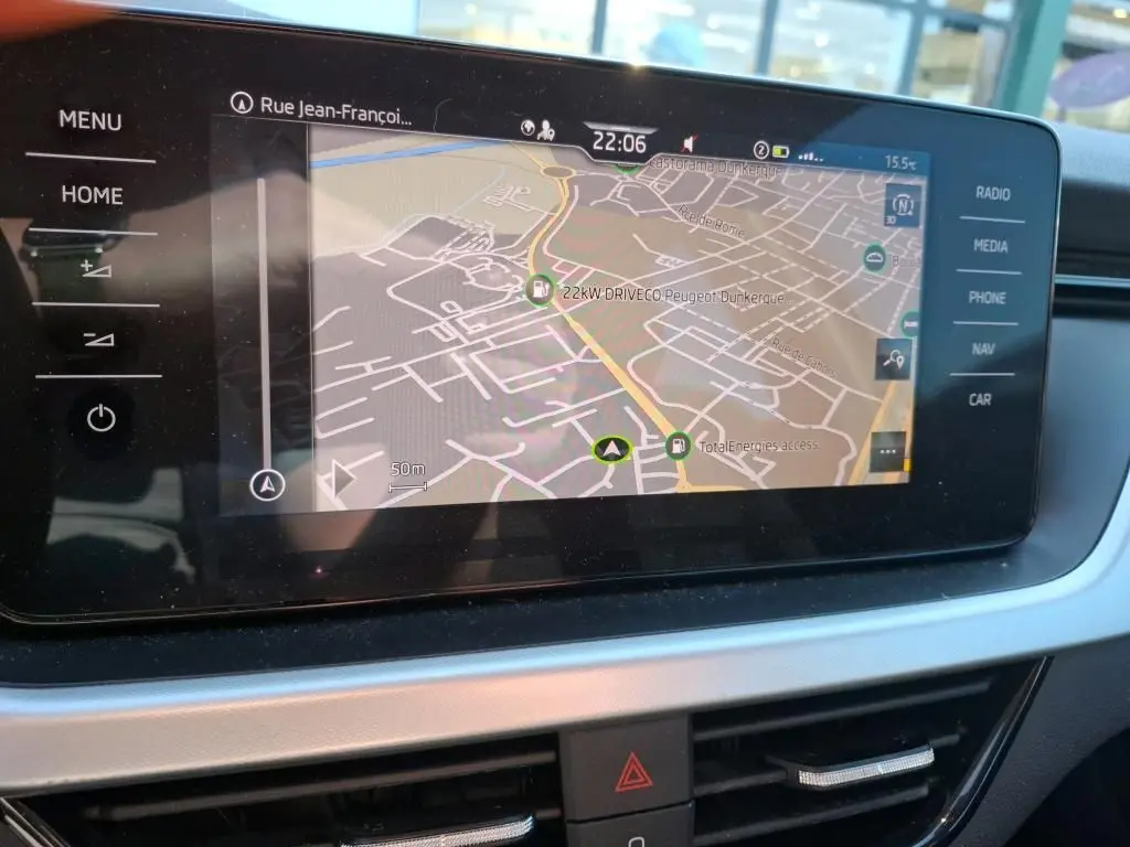 Écran tactile central du Skoda Kamiq 2023 affichant la navigation GPS avec commandes tactiles sur les côtés.