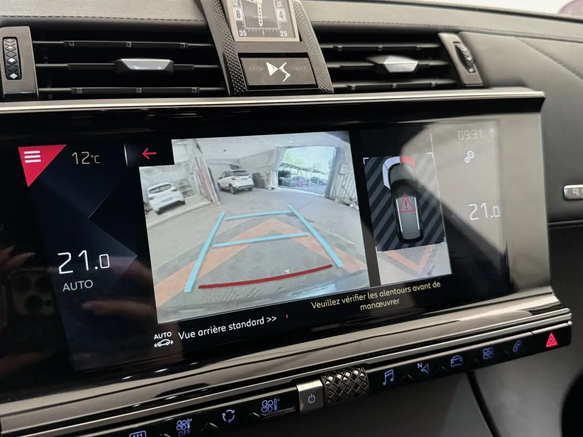 Écran tactile central du DS7 Crossback gris foncé montrant la caméra de recul et l'aide au stationnement.