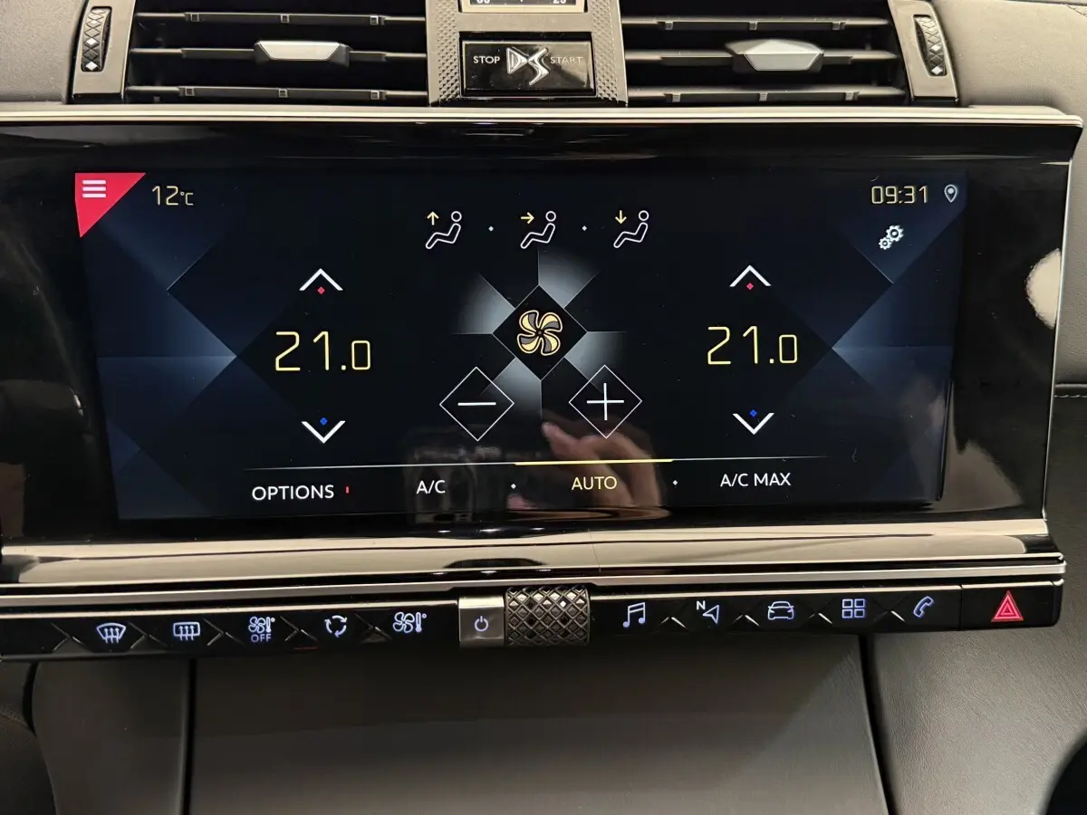 Gros plan sur l’écran tactile central du DS7 Crossback gris foncé, affichant la climatisation à 21°C en mode automatique.