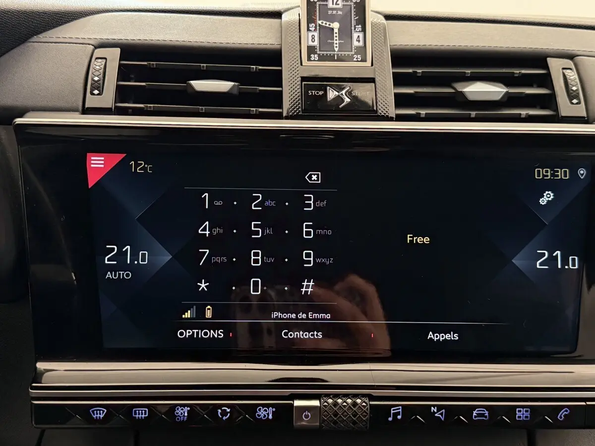 Vue rapprochée de l’écran tactile central du DS7 Crossback gris foncé, affichant le clavier téléphonique et la température à 21°C.