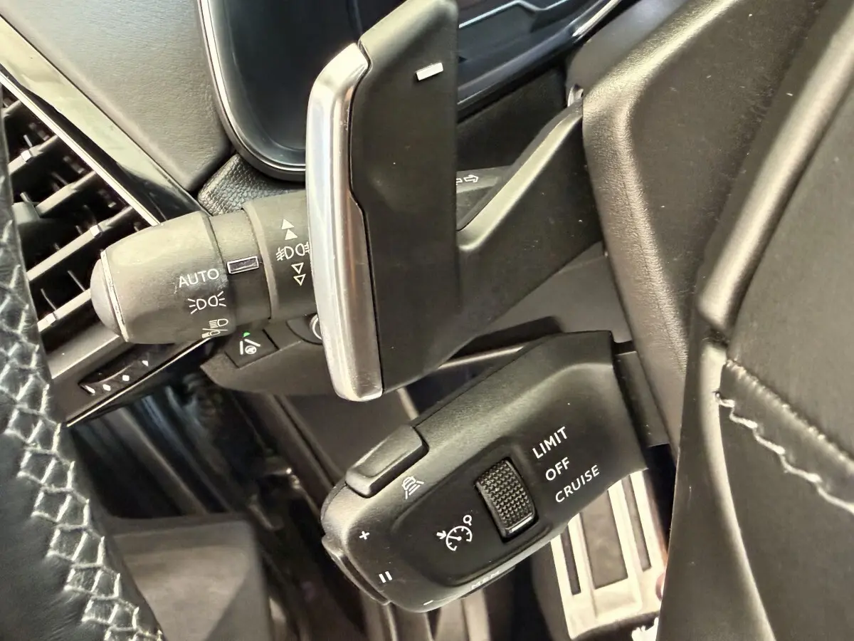 Gros plan sur la commande de régulateur de vitesse au volant cuir noir du DS7 Crossback gris foncé, version 2018.