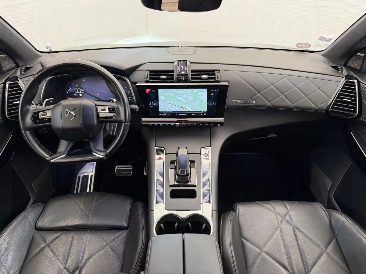 Vue intérieure avant du DS7 Crossback avec tableau de bord cuir matelassé et écran tactile central 12 pouces.