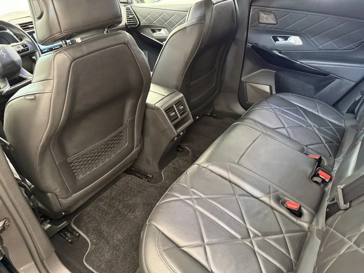 Vue intérieure arrière côté droit du DS7 Crossback avec sièges en cuir noir matelassé et finitions élégantes.