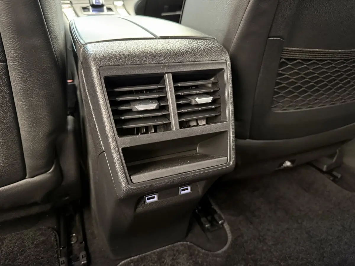 Vue rapprochée des aérateurs arrière et ports USB du DS7 Crossback gris foncé, intérieur cuir noir.