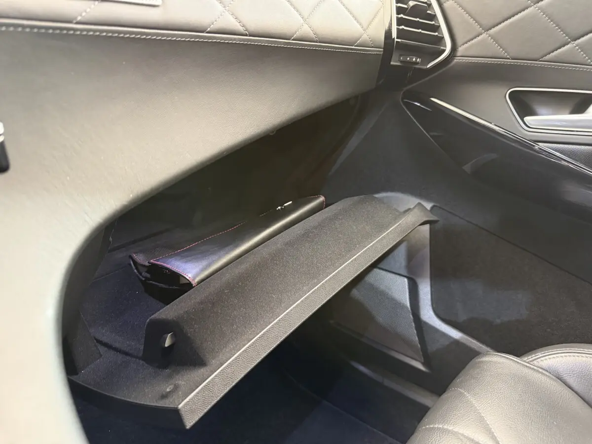 Vue intérieure côté passager du coffre à gants ouvert en cuir noir matelassé du DS7 Crossback gris foncé 2018.