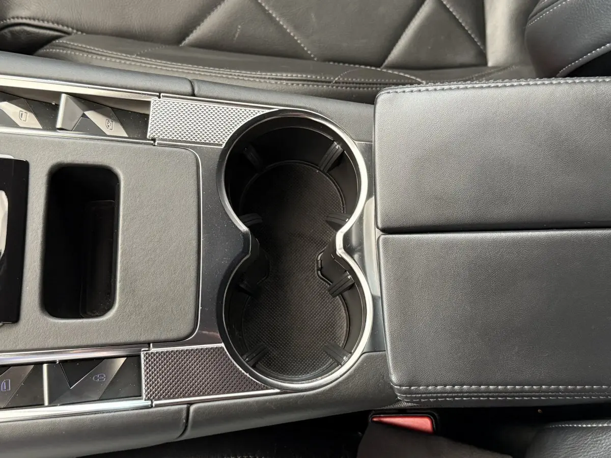 Gros plan sur la console centrale noire du DS7 Crossback 2018, mettant en valeur les porte-gobelets et accoudoir cuir.