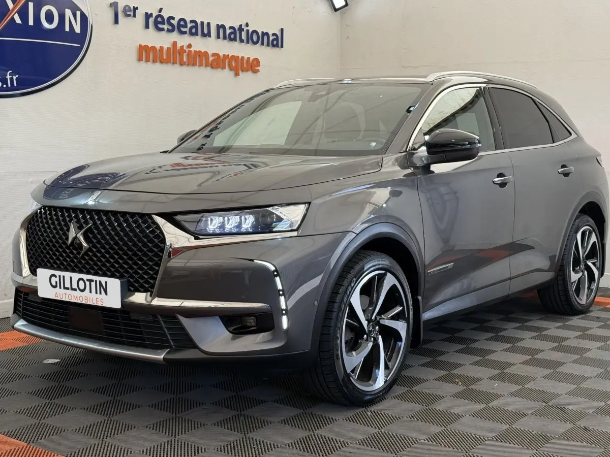 DS7 Crossback gris foncé en 3/4 avant droit, avec calandre distinctive et jantes alliage bicolores.