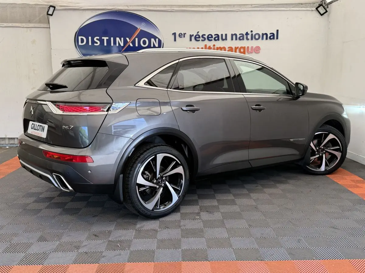 Vue 3/4 arrière droite du DS7 Crossback gris foncé avec jantes alliage bicolores et feux arrière LED distinctifs.