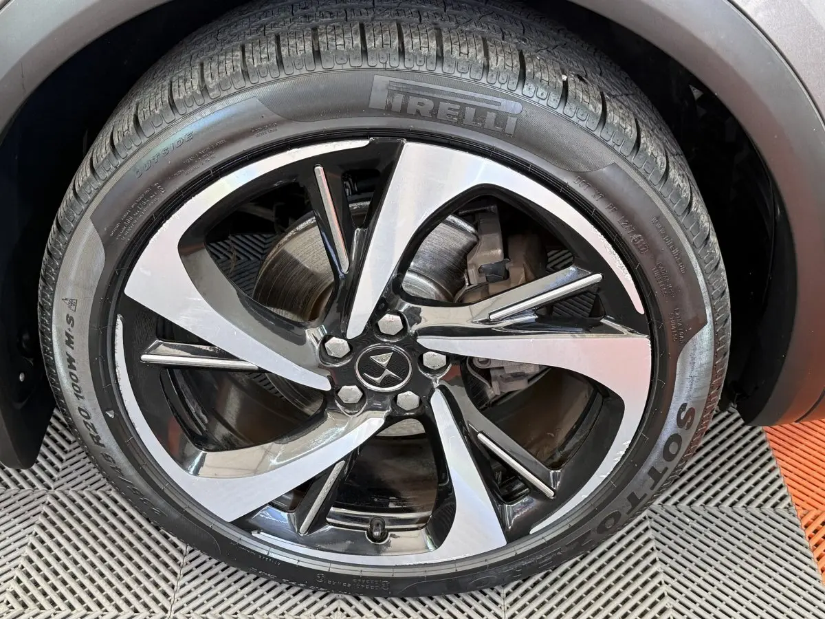 Gros plan sur la jante alliage bicolore et pneu Pirelli d’un DS7 Crossback gris foncé, vue côté droit.