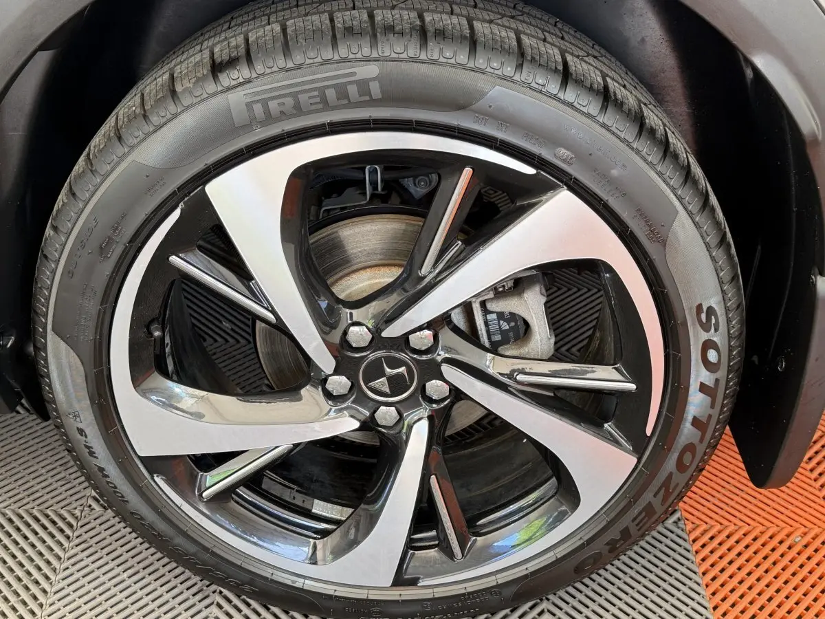 Gros plan sur la jante alliage bicolore et pneu Pirelli d’un DS7 Crossback gris foncé, côté droit.