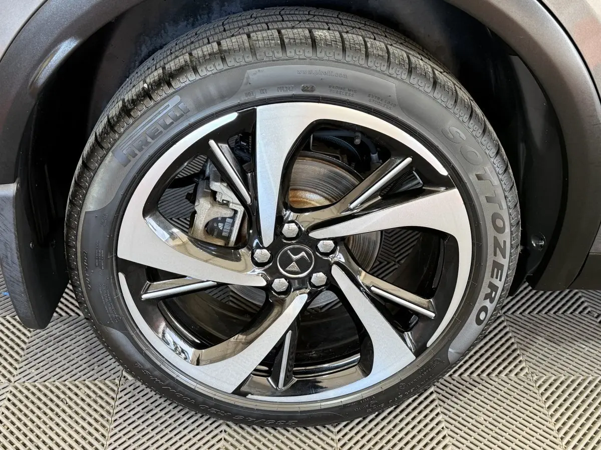 Gros plan sur la roue avant droite du DS7 Crossback gris foncé avec jante alliage bicolore et pneu Pirelli Sottozero.