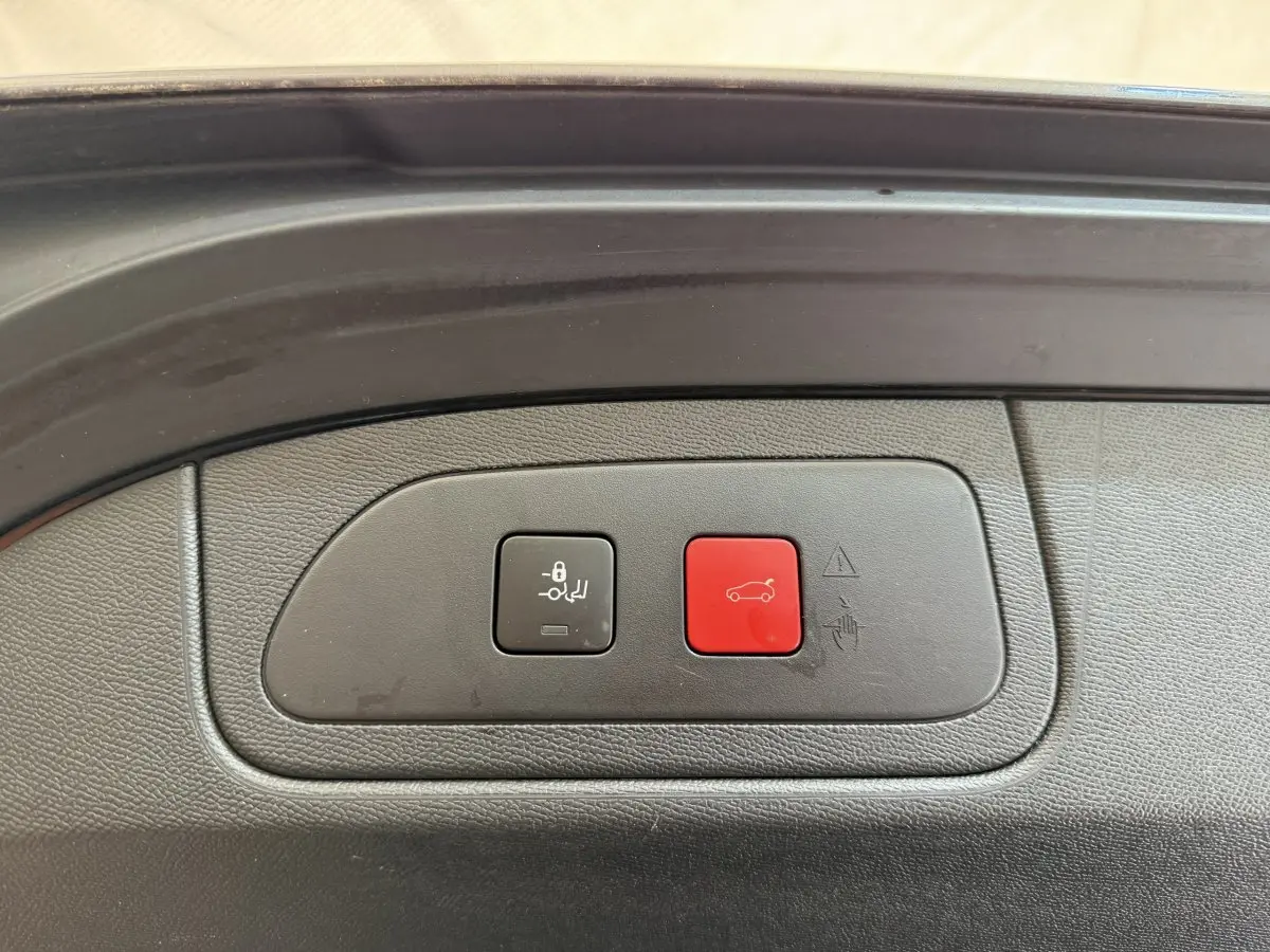 Boutons de commande du coffre électrique sur le bord intérieur d’un DS7 Crossback gris foncé, vue rapprochée.
