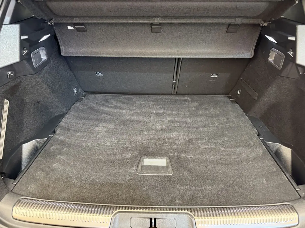 Vue intérieure du coffre spacieux gris foncé du DS7 Crossback PureTech 180 Grand Chic, avec cache-bagages déployé.