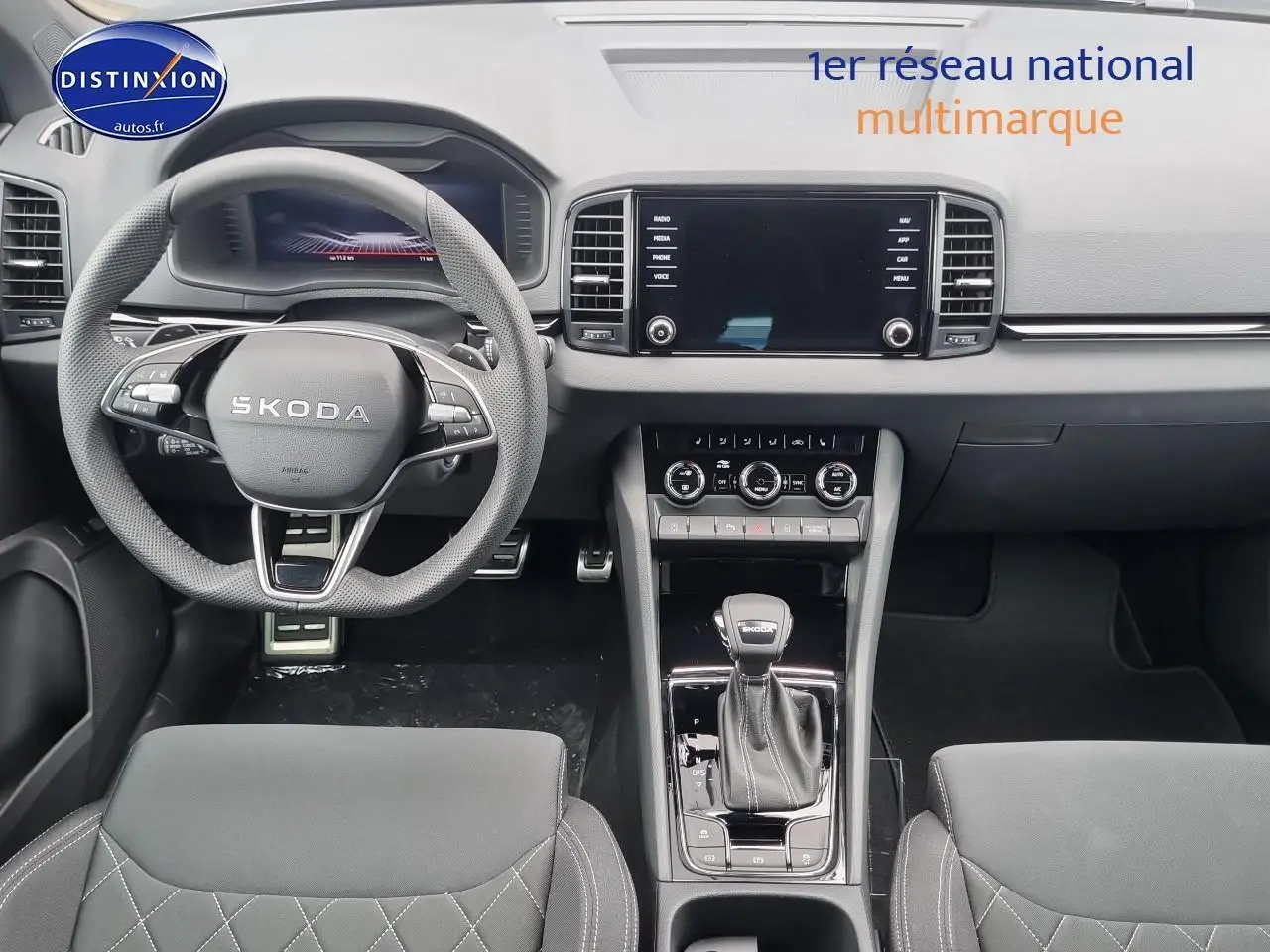 Vue intérieure frontale du tableau de bord et volant cuir noir du Skoda Karoq 1.5 TSI Sportline 2025.