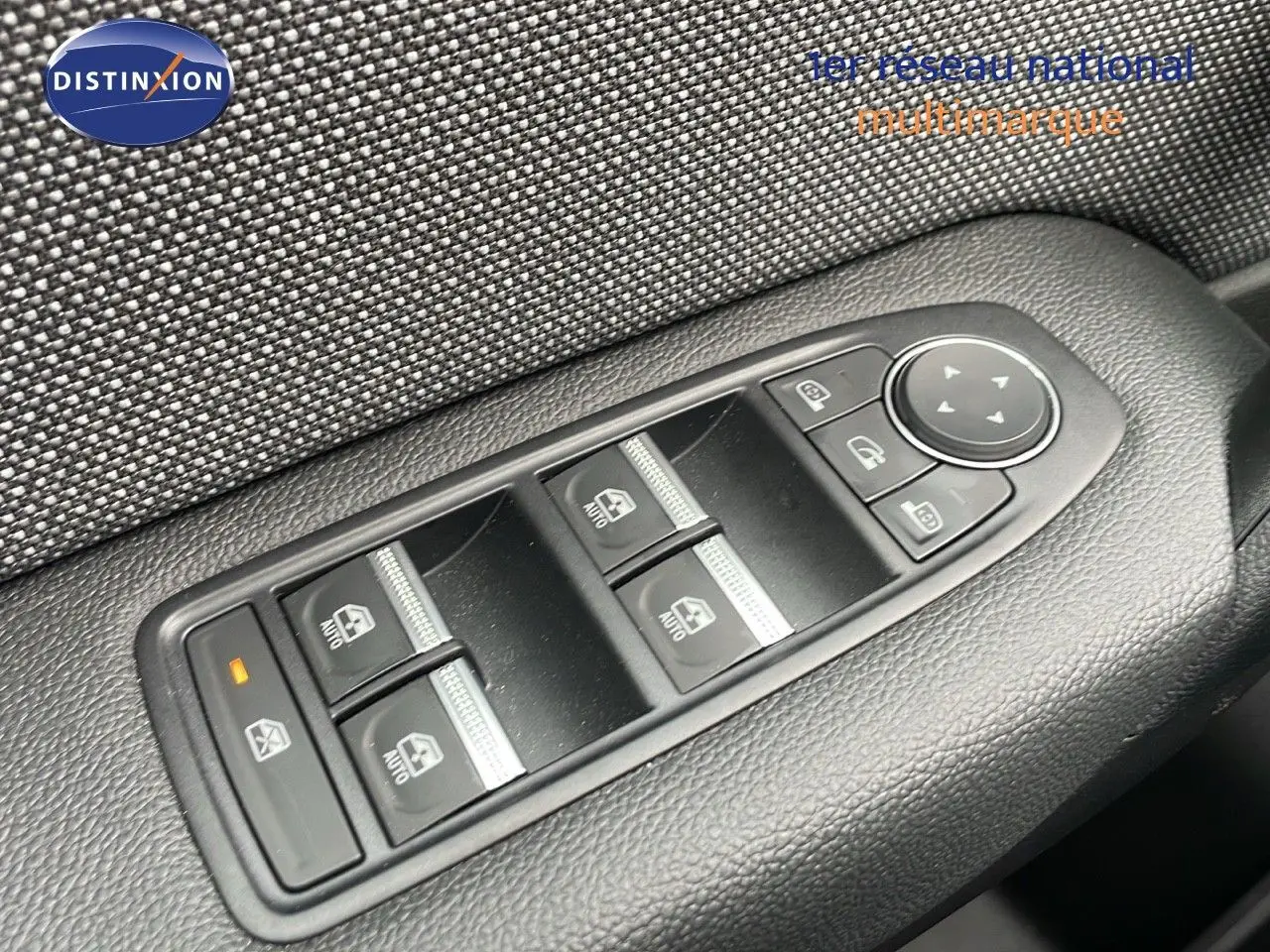 Gros plan sur les commandes de lève-vitres et rétroviseurs du côté conducteur du Renault Captur gris Rafale 2025.