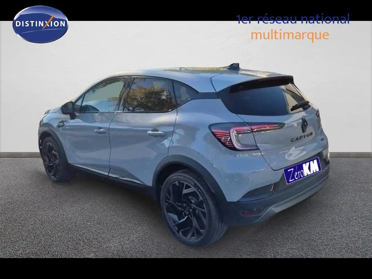 Renault Captur E-Tech hybride gris Rafale en 3/4 arrière côté gauche avec jantes noires et toit gris.