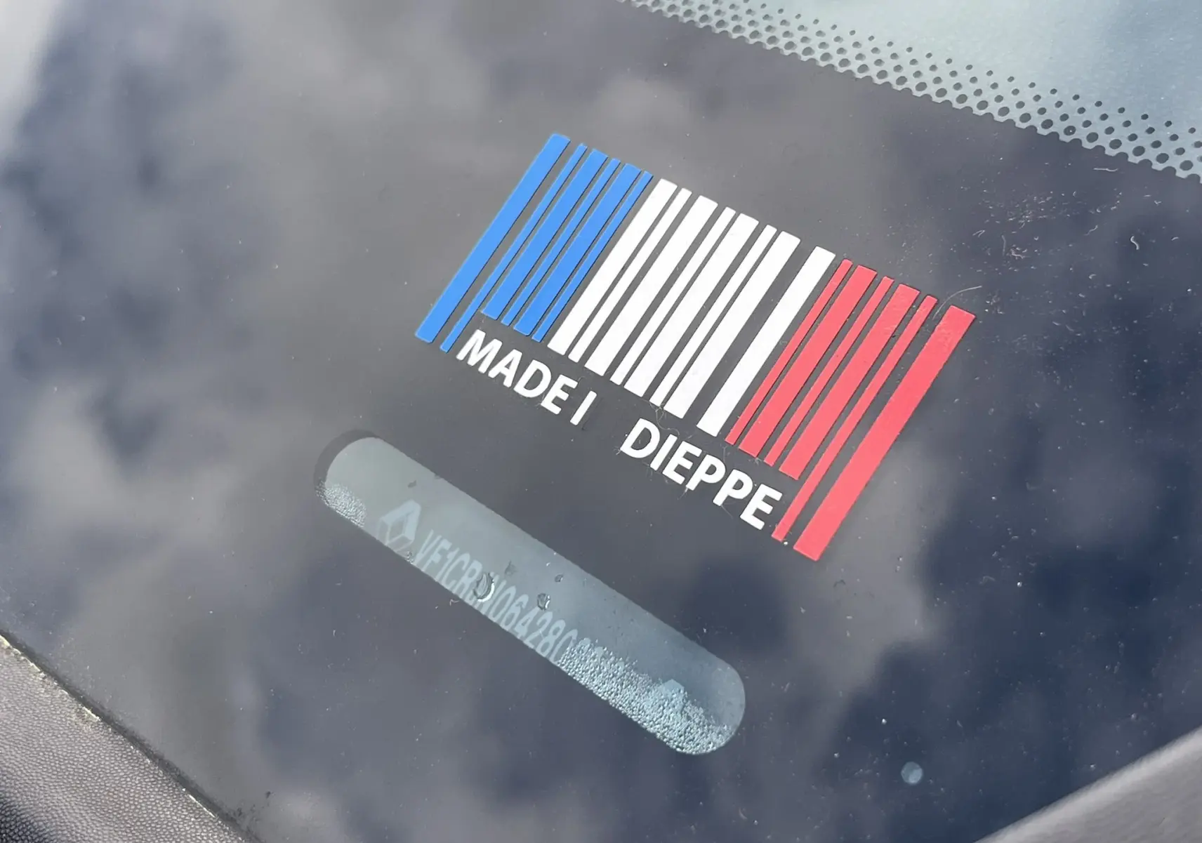 Gros plan sur le pare-brise d'une Renault Clio III RS 20th Anniversary avec un sticker tricolore "Made in Dieppe".