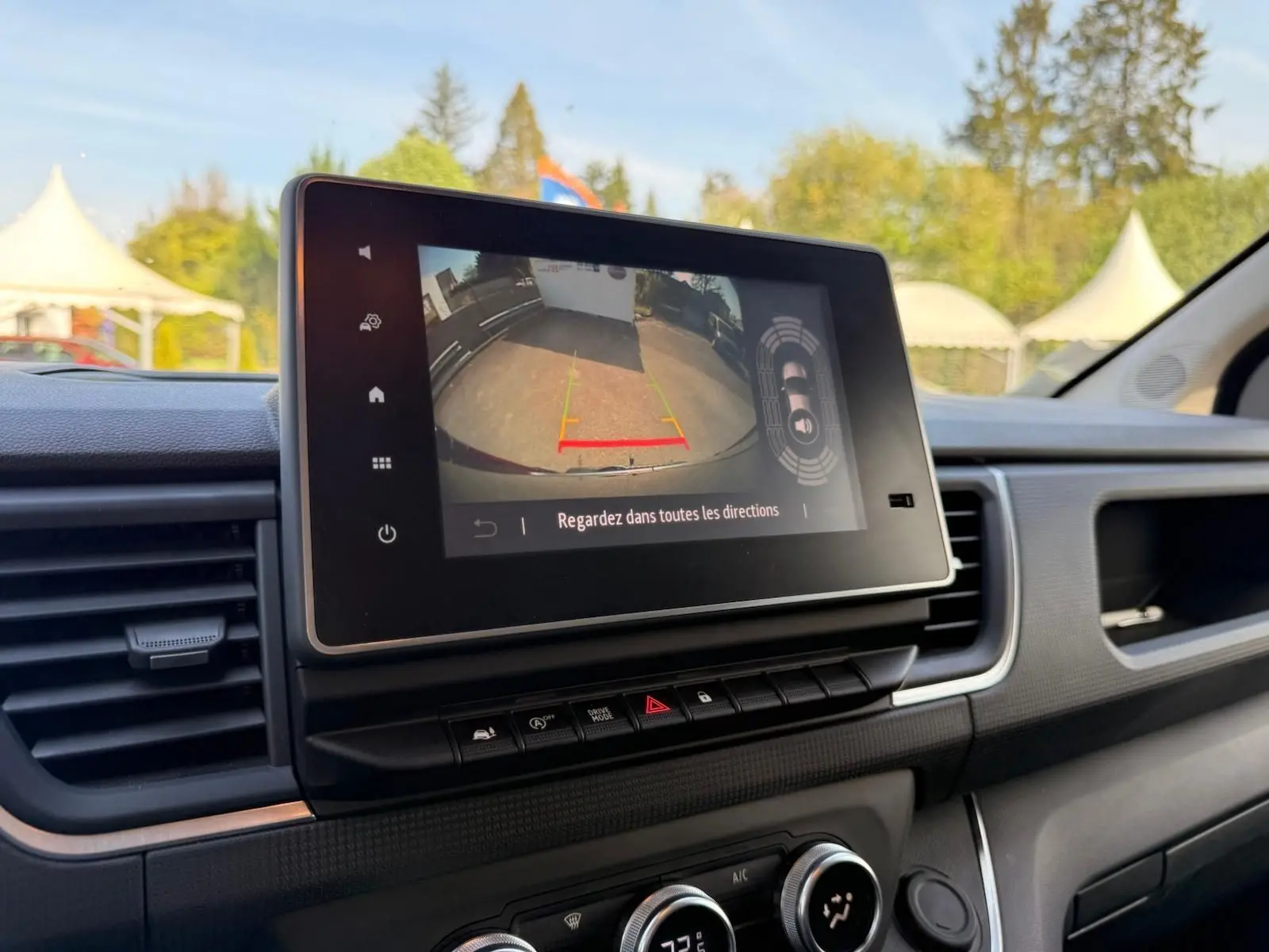 Vue rapprochée de l’écran tactile intérieur du Renault Trafic gris comète, affichant la caméra de recul avec guidage.