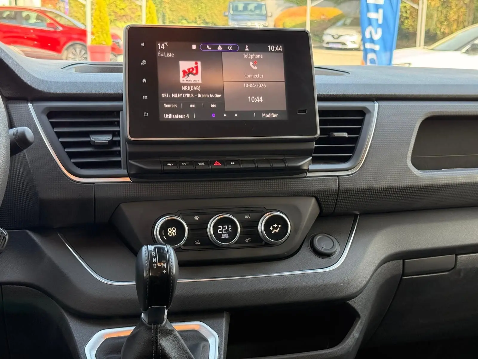 Vue intérieure du tableau de bord du Renault Trafic L1H1 2024, écran tactile et commandes climatisation visibles.
