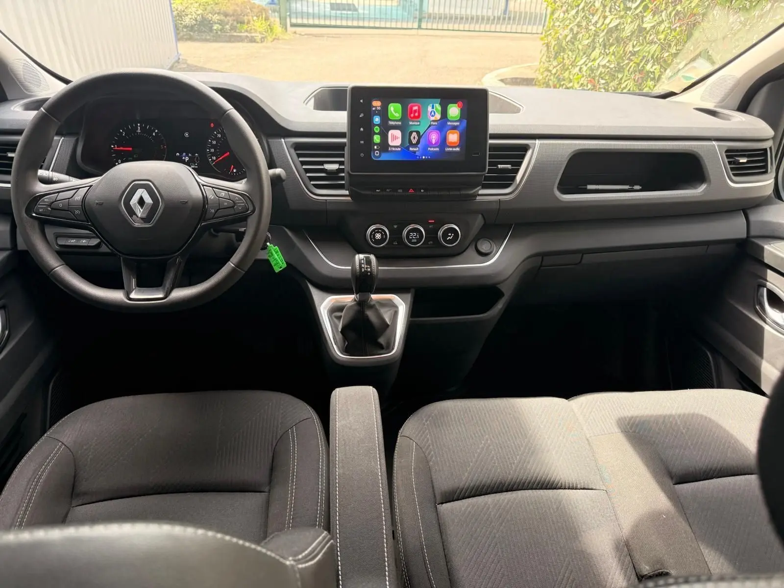 Vue intérieure frontale du poste de conduite du Renault Trafic Cabine Approfondie 2024 avec tableau de bord moderne et écran tactile central.