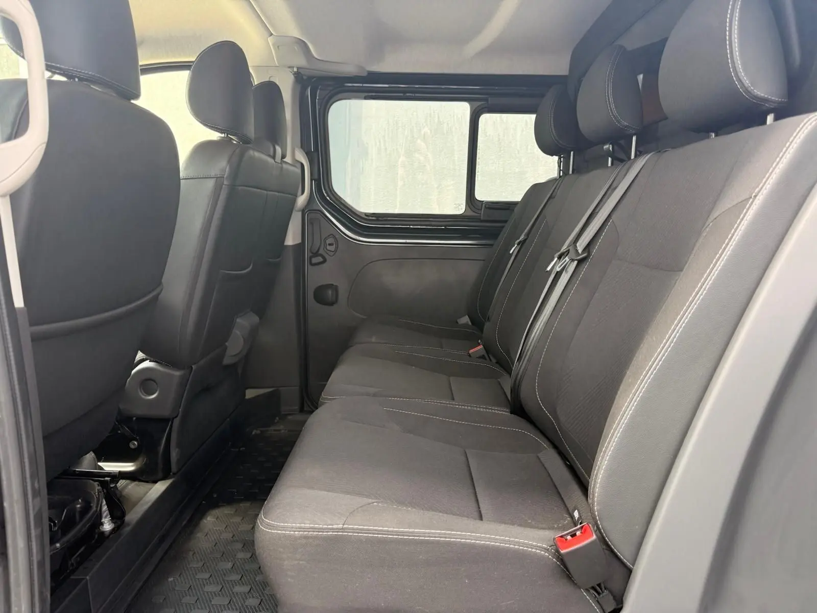 Vue intérieure côté droit sur la banquette arrière noire du Renault Trafic Cabine Approfondie gris comète 2024.