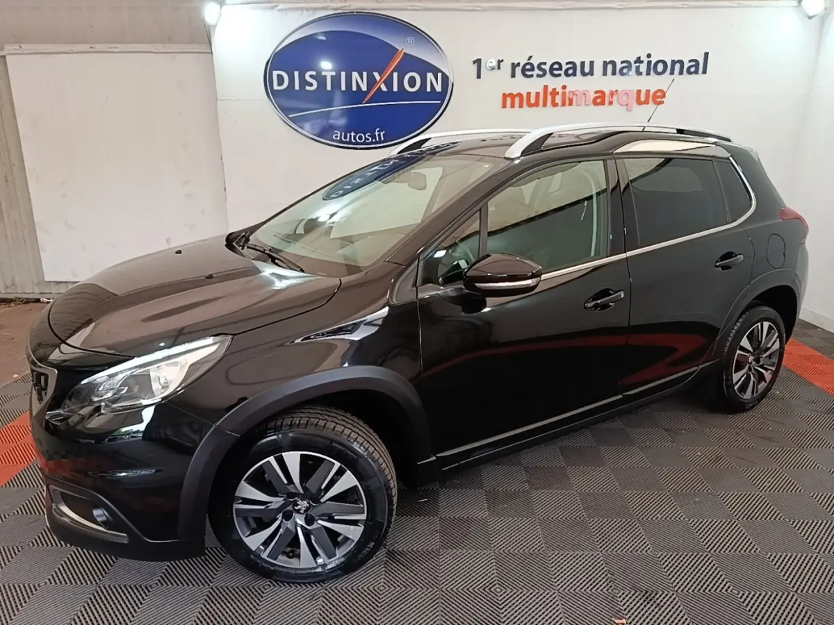 Peugeot 2008 noir en vue de profil côté gauche, avec jantes alliage et rails de toit chromés visibles.
