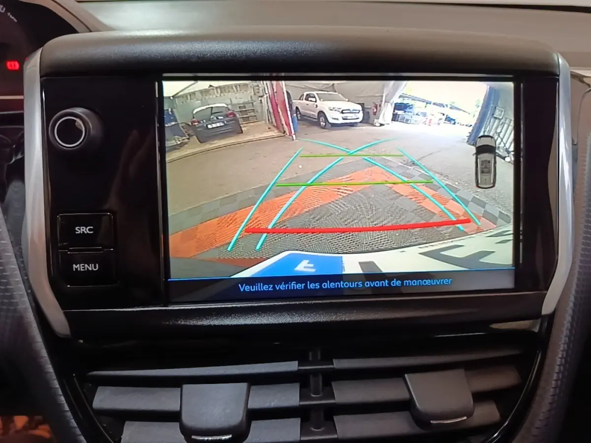 Écran tactile intérieur montrant la caméra de recul d'une Peugeot 2008 noire, vue arrière avec guidage de trajectoire.