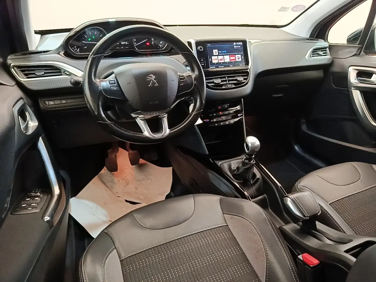 Vue intérieure avant du Peugeot 2008 avec volant cuir, tableau de bord digital et écran tactile central.
